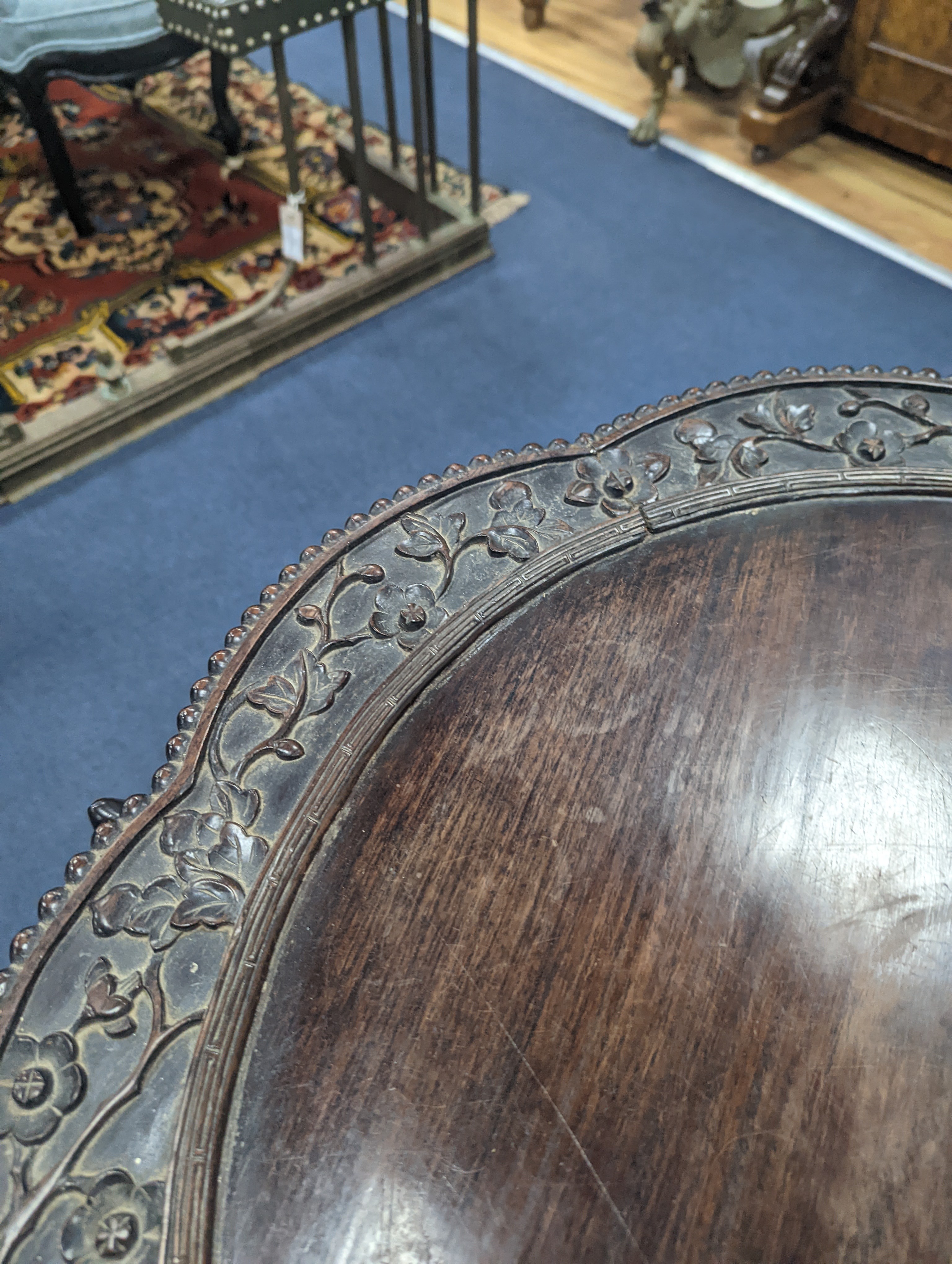 An early 20th century Chinese carved hardwood two tier table, diameter 64cm, height 56cm